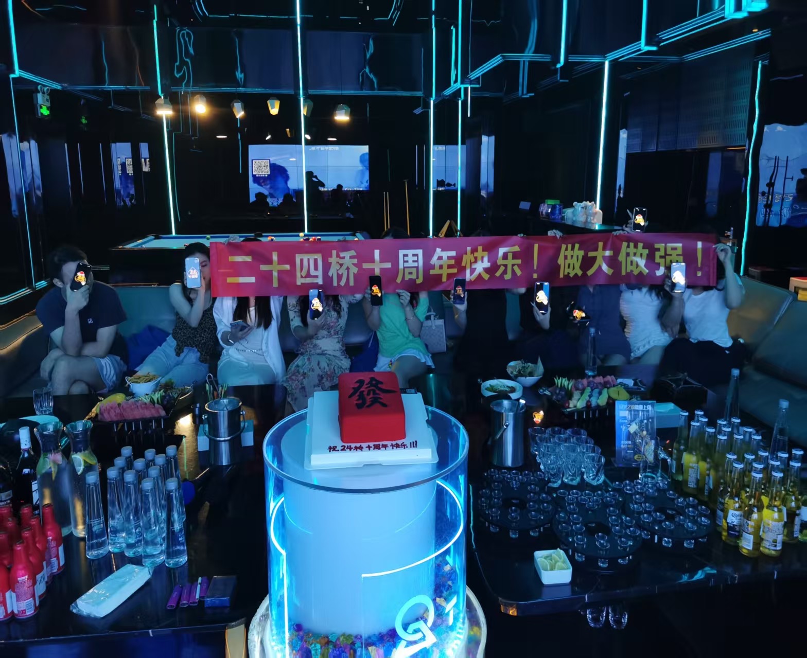 朋友们举着二十四桥十周年横幅的聚会合照